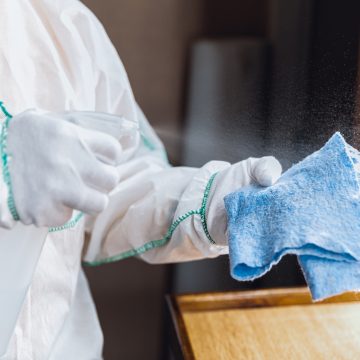 Coronavirus Pandemic. A disinfector in a protective suit and mask sprays disinfectants in the house or office Boom en la nueva normalidad: 4 Razones para invertir en el sector de limpieza