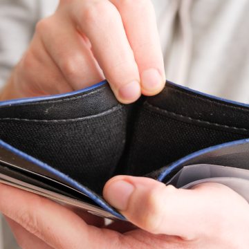 Man hand showing an open empty wallet close up. Poverty, cost control expenses, spent too much, not enough cash, lost money concept idea. Top or above view. 3 tipos de gastos que dañan tus finanzas
