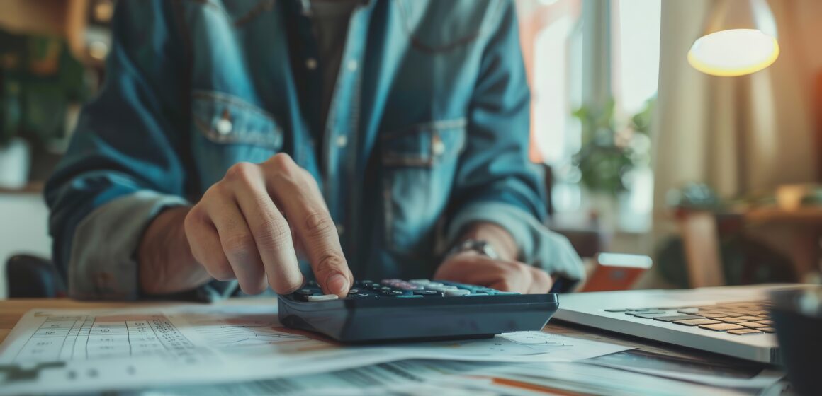 Person using a financial calculator, planning their savings and investments ¿Pagas a una cuenta distinta de la de tu proveedor?: cuándo debes informar a la SUNAT